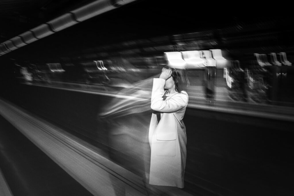 Persona sulla banchina della metropolitana, metafora di ansia e solitudine